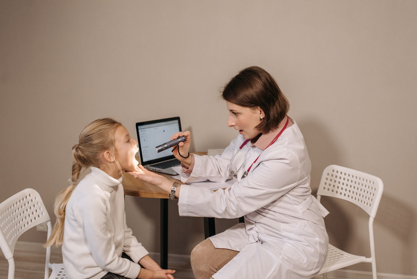 Doctora conversando con una niña en consulta