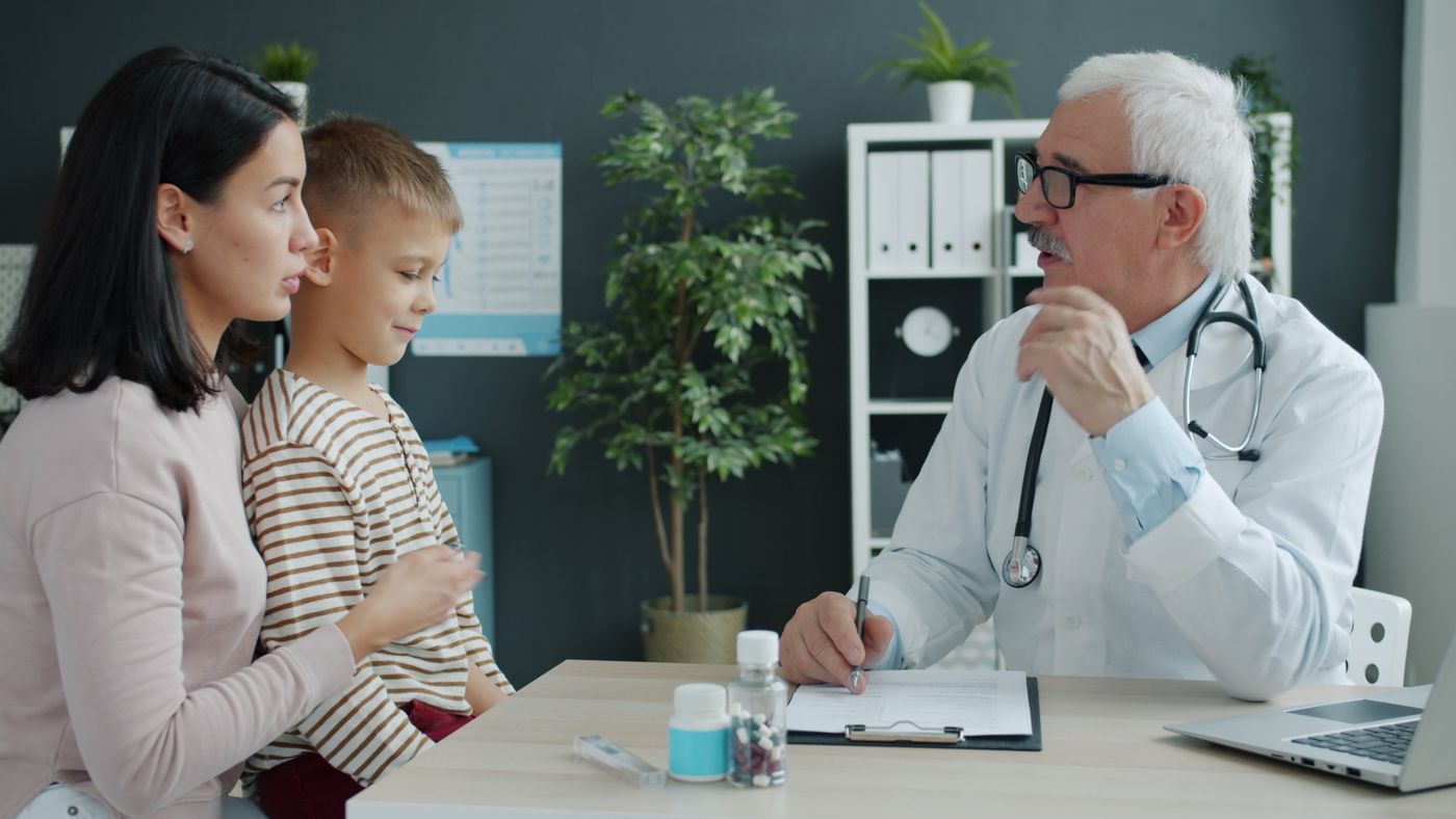 Doctor conversando con una madre y su hijo